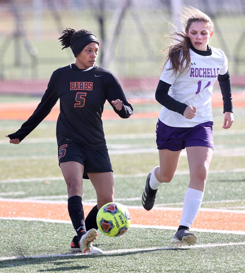 DeKalb's Madison McNeil carries the ball up field ahead of Rochelle's Makayla Lara during their game Thursday, April 14, 2022, at DeKalb High School.