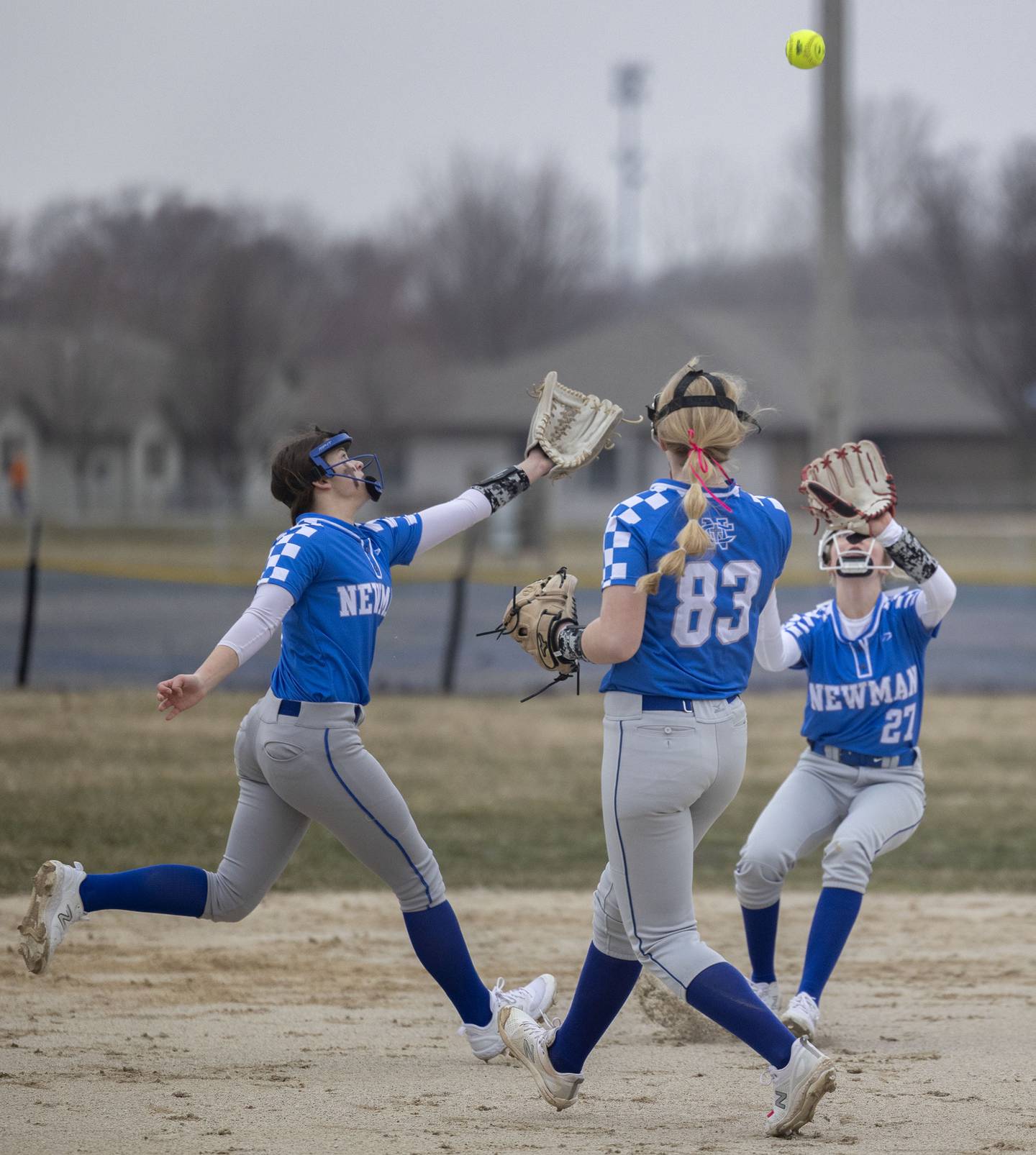 Newman’s Lucy Oetting (left), Jess Johns and Brenleigh Cook come together for a pop up Wednesday, March 22, 2023 against Annawan-Wethersfield.
