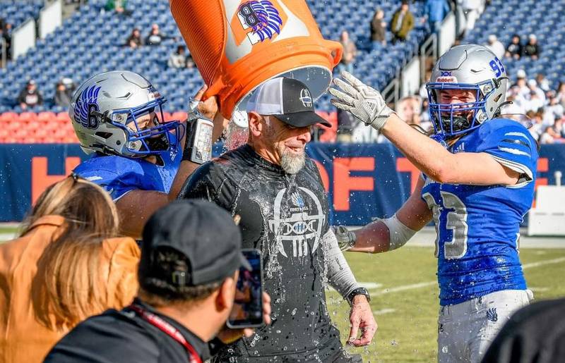 Blair Hubbard, a 1987 Princeton High School, gets a water bucket shower courtesy of his Broomfield football players after winning the Colorado 4A state championship Saturday in Denver.