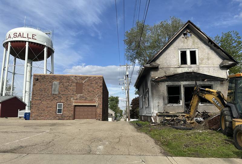 A backhoe begins to demolish a home located in the 800 block of Bucklin Street on Thursday, May 7, 2026 in La Salle. The home was destroyed by a fire on Jan. 23. Firefighters worked together to battle the blaze in subzero temperatures.