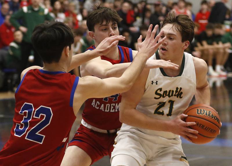 Crystal Lake South's Cooper LePage drives into the defense of Marmion’s Henry Dalmann, (left) and Evan Stumn during a IHSA Class 3A Sectional boys basketball game Tuesday, Feb. 28, 2023, at Central High School in Burlington.
