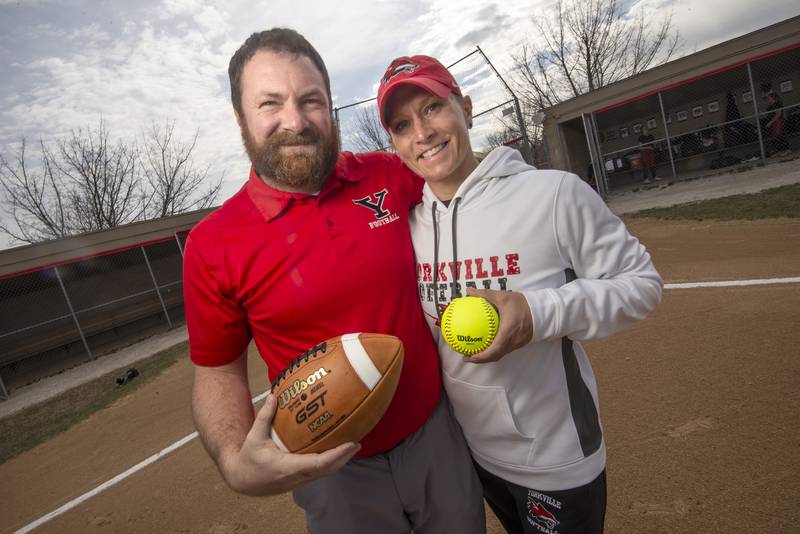 Yorkville High School coaching couple Tom Regnier, a football coach and Jory, a softball coach, pose together at the varsity girls softball field on Monday, April 11, 2022.