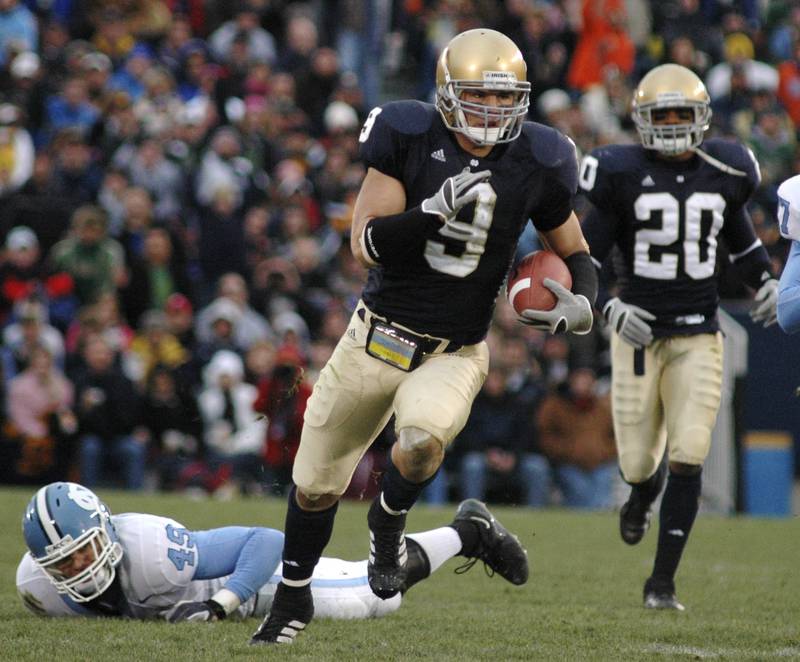 Notre Dame safety Tom Zbikowski, center, heads to the end zone on a 52-yard punt return after getting past North Carolina punter David Wooldridge, left, in the second quarter of college football action in South Bend, Ind., Saturday, Nov. 4, 2006. (AP Photo/Joe Raymond)