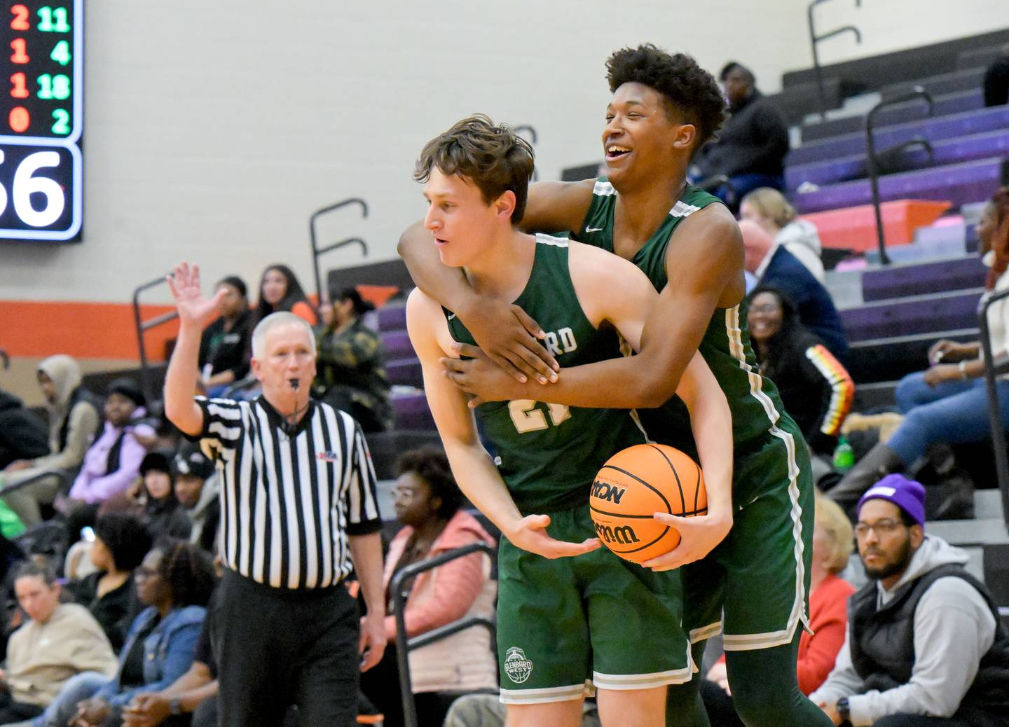 Glenbard West's Bryce Huff (21) and Logan Glover (20) celebrate the Hilltoppers 56-51 win over DeKalb on Wednesday, Dec. 4, 2024.