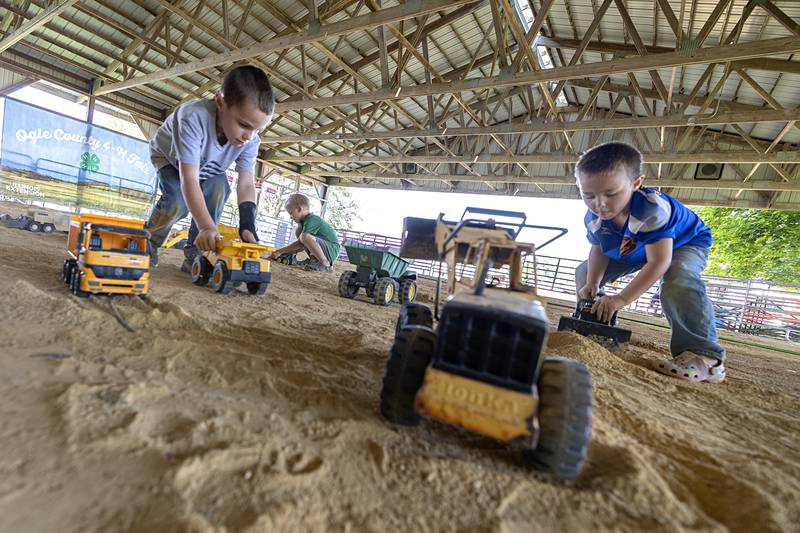 Rowen Eckerstrom (left), 6, Mace Hubbard, 7, and Owen Safranek, 4, dig into the ground Wednesday, July 31, 2024 at the Ogle County Fair. The three were enjoying moving earth and getting dirty on the first day of the fair.