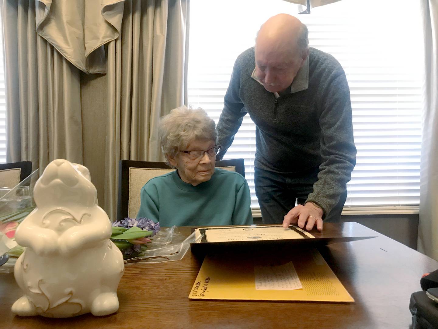 Don Hall, friend and former neighbor of Mary Voss, reads the certificate sent to her by Rep. Tony McCombie and the Illinois General Assembly.