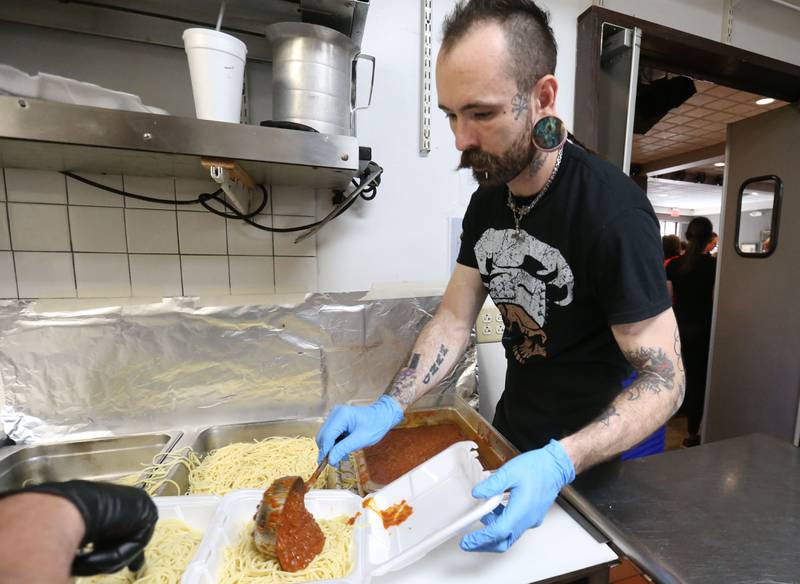 Zak Byrnes fills spaghetti into to-go containers during the Lighted Way spaghetti dinner on Monday, April 28, 2025 at Uptown Bar & Grill downtown La Salle.
