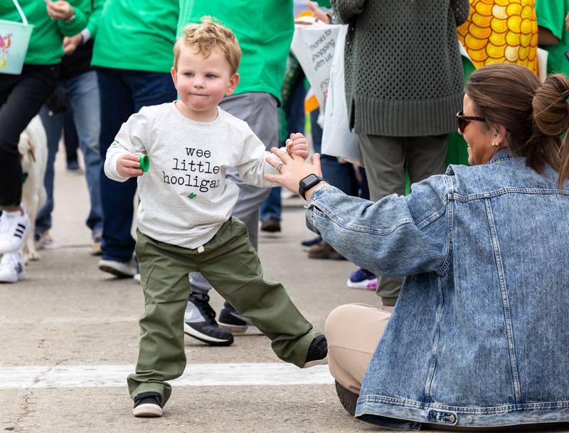 Michael Nightingale, 2, dances with his mom Christine Nightingale to music from the St. Charles St. Patrick’s Parade on Main Street in St. Charles on Saturday, March 15, 2025.