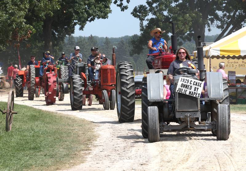 Antique tractors roll down the street Thursday, Aug. 8, 2024, during the 67th annual Sycamore Steam Show and Threshing Bee at Taylor Marshall Farm.