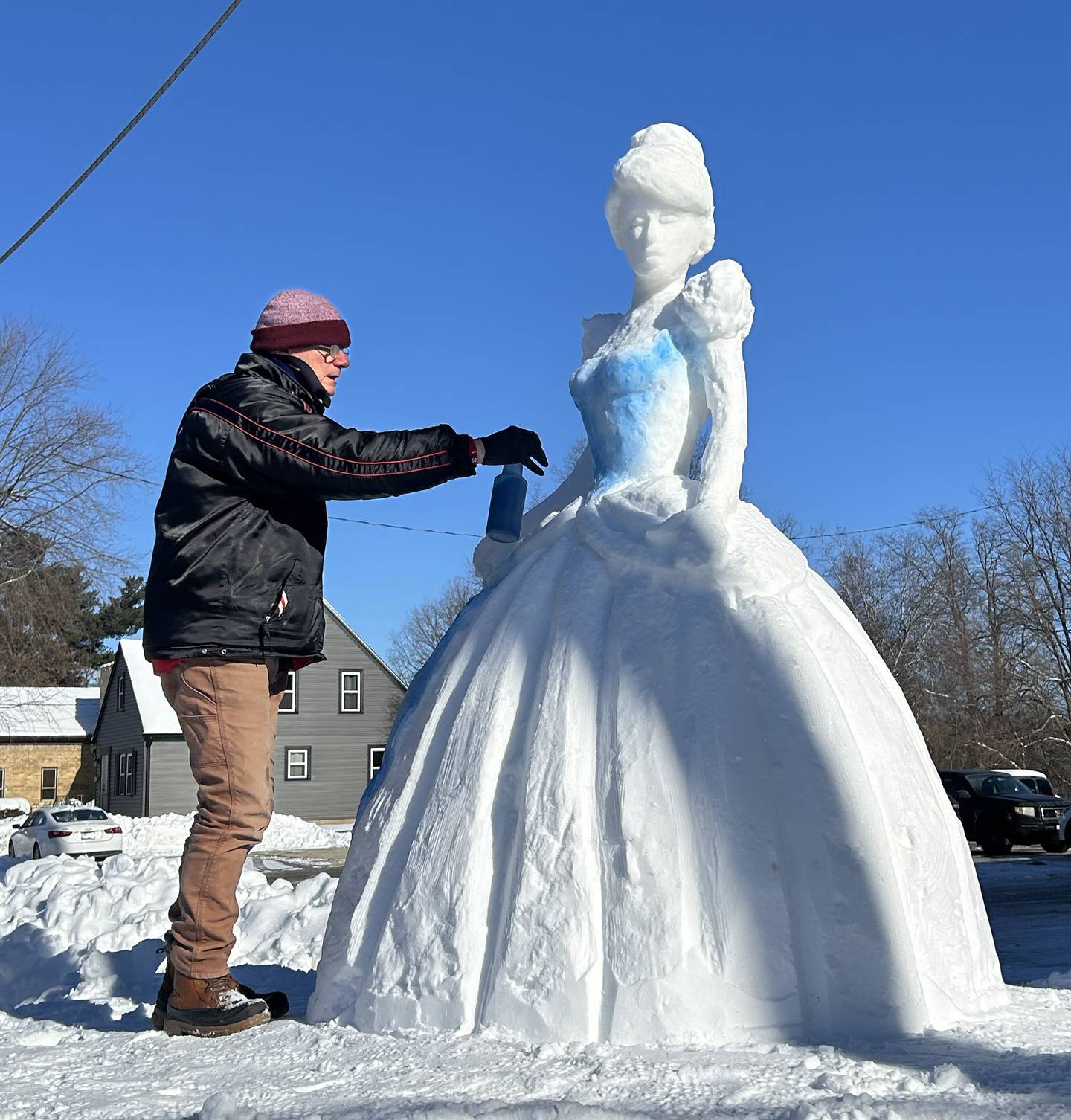 Fran Volz paints the Cinderella snow sculpture he created on the northwest corner of Conover Square, 203 N. 3rd Street in Oregon on Thursday, Dec. 4, 2025. Folz has a store in the mall.