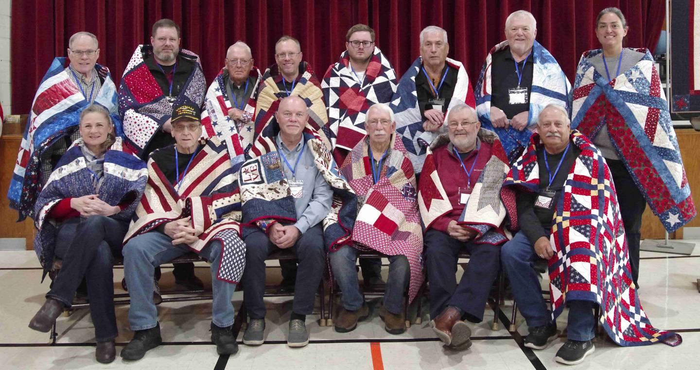 The 1 p.m. Quilts of Valor Presentation recipients are (back row, from left) David Brock, Ryan Nolan, Harry Reeser, Craig Dimmig, Jerry Lanning, Jim Eccelson, Melissa Zavada, (front row) Kristy Roemer, Dan Gillman, Todd Galyen, Art Johnson, Jack Dzuris, Jack Bodznick Jr.