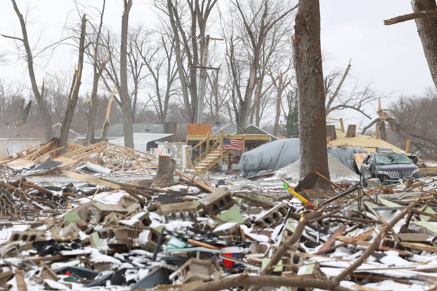 Snow falls on the destroyed homes along South Sandbar Road in Aroma Township on March 16, 2026, following the March 10 EF-3 intensity tornado in Kankakee County.