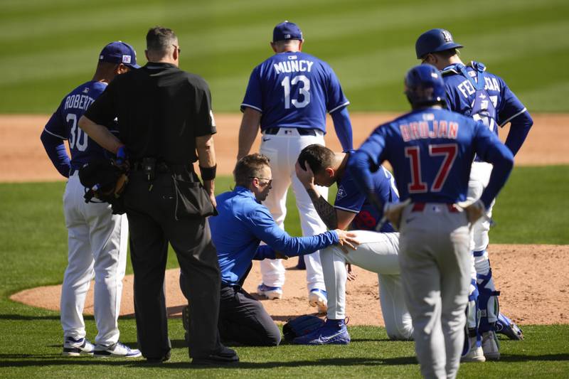 Los Angeles Dodgers pitcher Bobby Miller reacts after being hit by a line drive from Chicago Cubs' Michael Busch during the third inning of a spring training baseball game, Thursday, Feb. 20, 2025, in Glendale, Arizona. (AP Photo/Ashley Landis)
