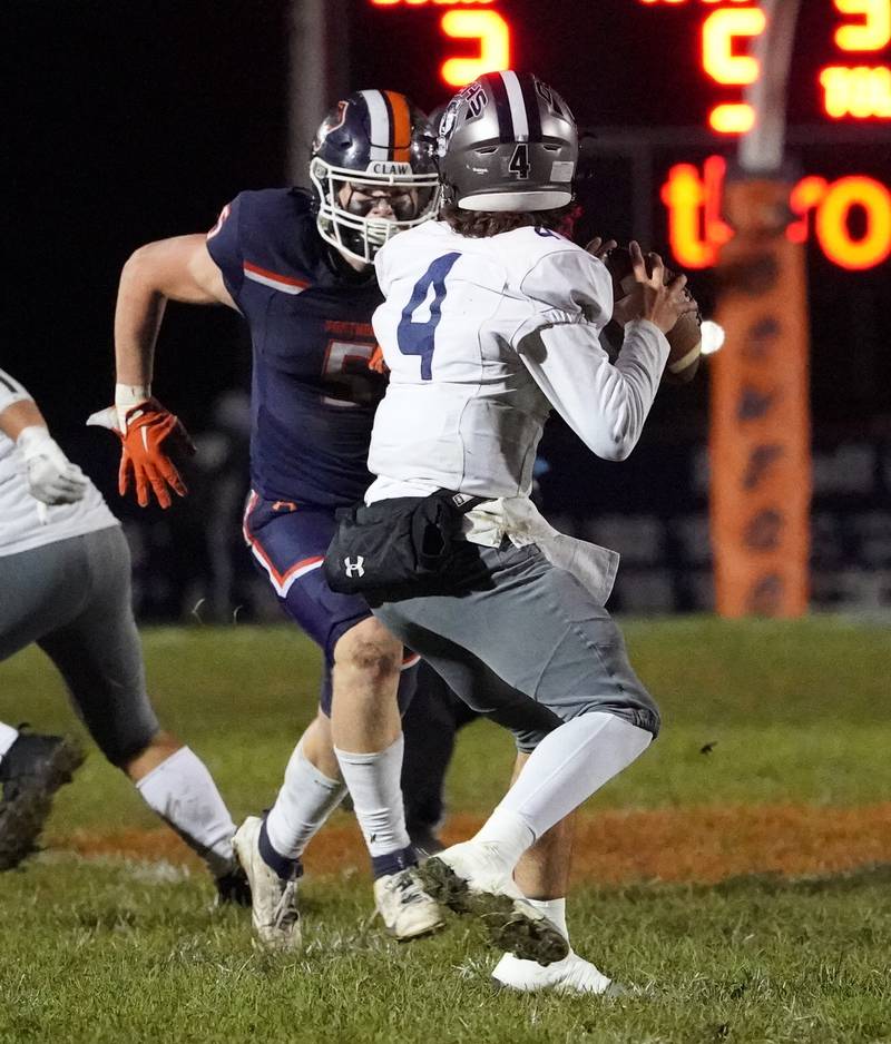 Oswego’s Carson Cooney (5) blitzes Oswego East's Niko Villacci (4) during a football game at Oswego High School on Friday, Oct. 20, 2023.