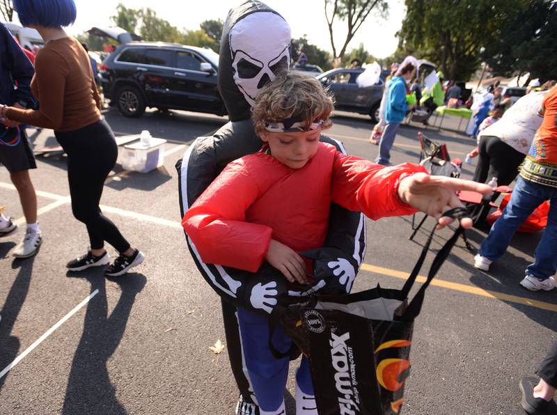 Children including Henry Lusignan of La Grange gets candy on Saturday, Oct. 12, 2024 during a Trunk or Treat event at Sedgwick Park in La Grange.