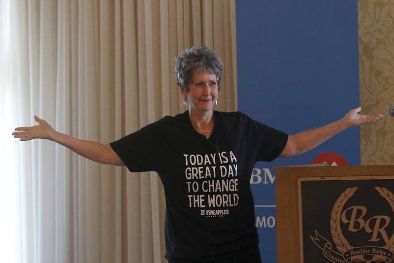 Terry Willcockson shows off her T-shirt as she speaks during the Northwest Herald's Women of Distinction award luncheon Wednesday June 29, 2022, at Boulder Ridge Country Club, 350 Boulder Drive in Lake in the Hills. The luncheon recognized 10 women in the community as Women of Distinction plus the first recipient of the Kelly Buchanan Woman of Inspiration award. Willcockson was among this year's Women of Distinction.