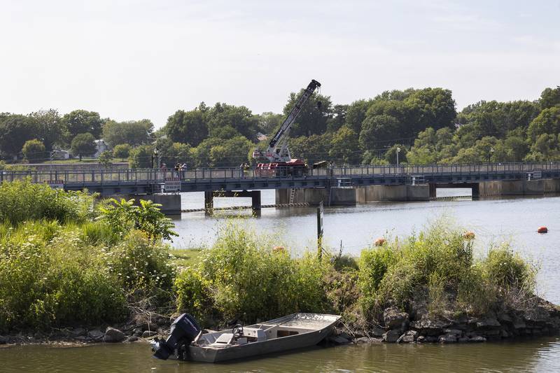 Workers perform maintenance on the upper dam Wednesday, July 19, 2023. For at least the next three days the pedestrian bridge crossing the dam will be closed for maintenance.