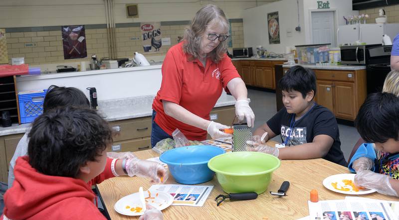 Judy Booze of the Streator Salvation Army, assists participants Wednesday at Northlawn Junior High in Streator during the Illinois Junior Chefs program. The Salvation Army, OSF Health and The University of Illinois-Extension coordinated the week long program.