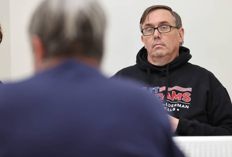 DeKalb City Council Ward 5 alderman Scott McAdams (right) listens as Derek Van Buer, one of the two DeKalb residents who filed objections against him, speaks Friday, Jan. 13, 2023, during a City of DeKalb Electoral Board hearing. The hearing was held to decide if incumbent McAdams, who is running unopposed for DeKalb’s 5th Ward aldermanic seat, should be removed from the ballot due to objections filed by two residents regarding signatures and filing procedure.