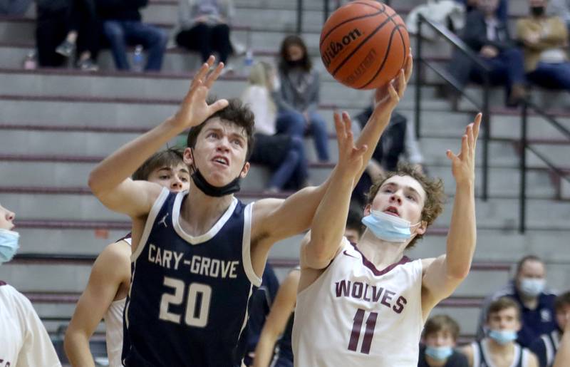 Prairie Ridge’s James Muse, right, and Cary-Grove’s Zachary Bauer battle for the ball during boys varsity basketball action in Crystal Lake Tuesday night.