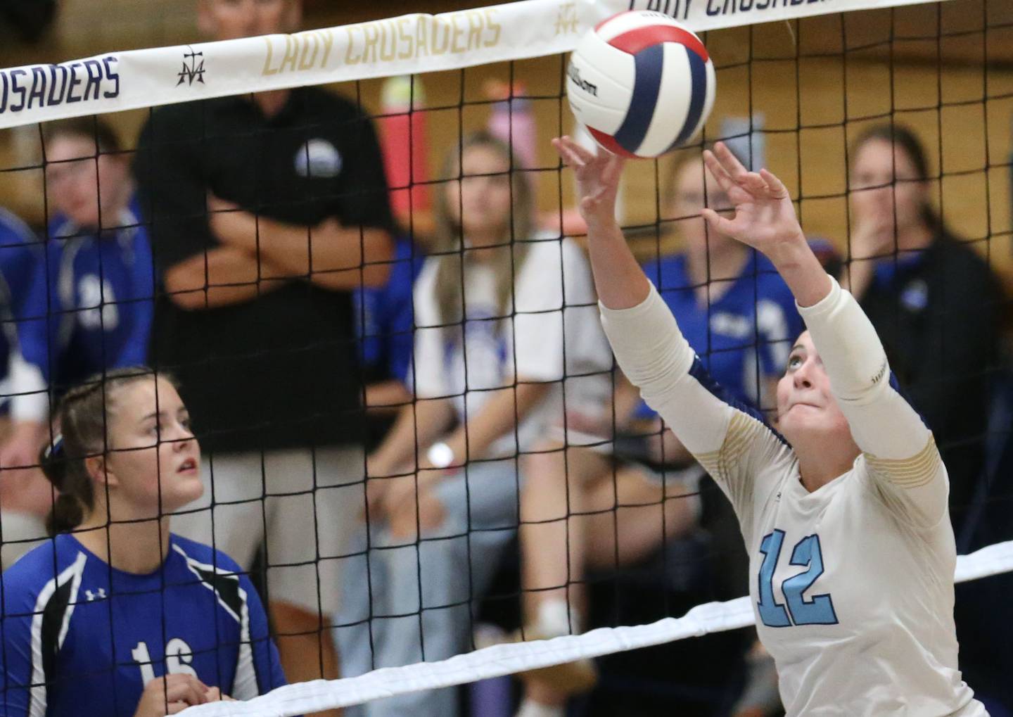 Marquette's Kinley Rick sets the ball in the air as Newark's Rylie Carlson watches the play on Wednesday, Aug. 27, 2025 in Bader Gymnasium.