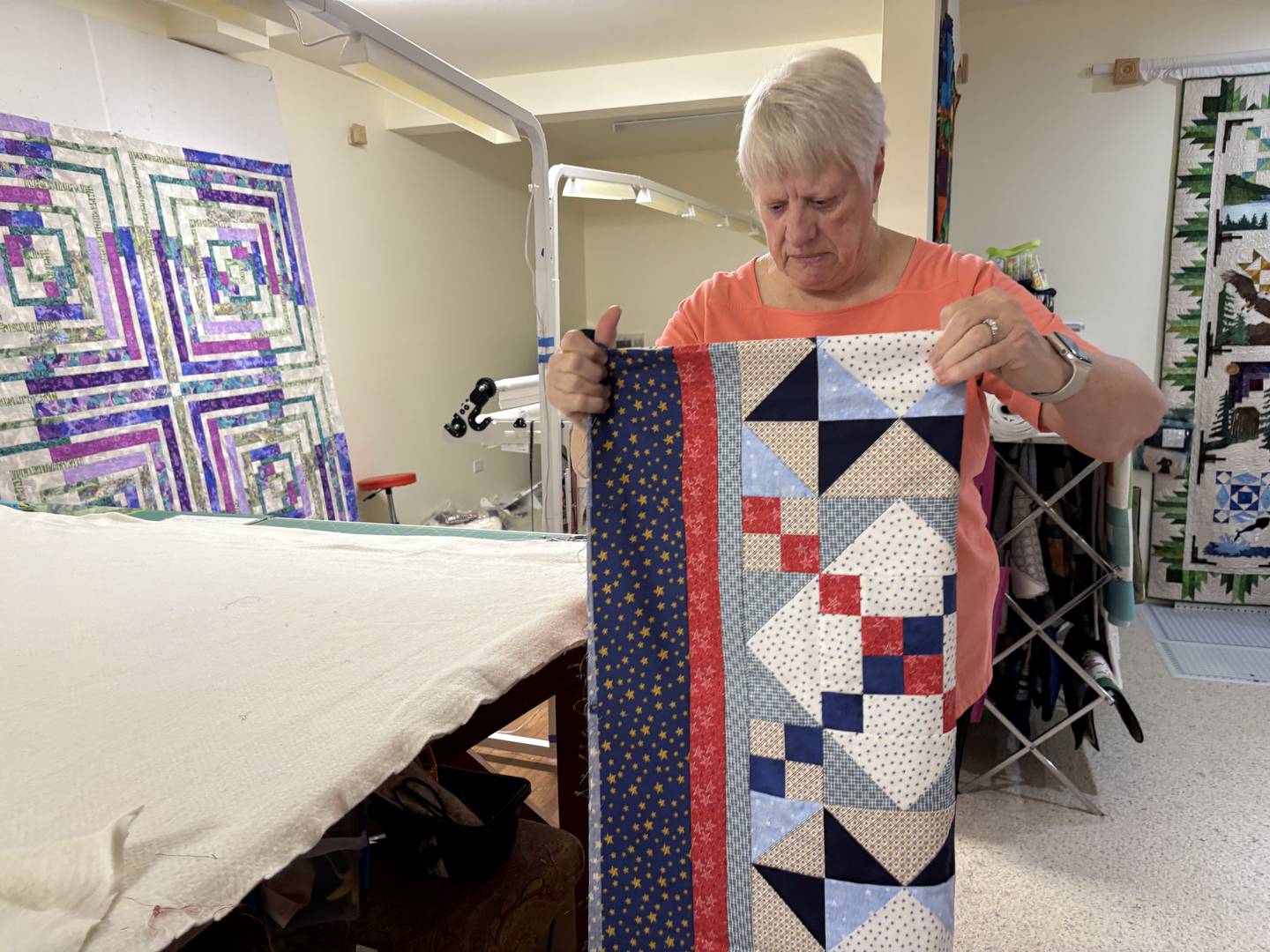 Joan Ausbury folds the top of a quilt Oct. 31, 2024 in Huntley.