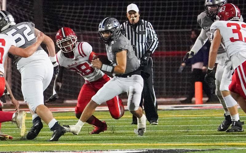 Oswego East's Niko Villacci (4) carries the ball on a keeper against Yorkville during a football game at Yorkville High School on Friday, Oct. 13, 2023.