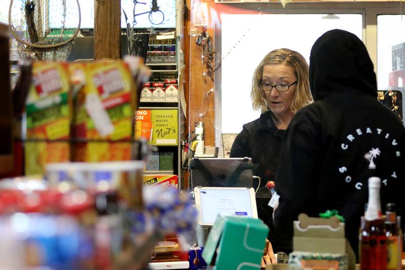 Store clerk Pam Donzelli rings up a customer at Creekside Country Store on Wednesday, Dec. 16, 2020, in Wonder Lake.