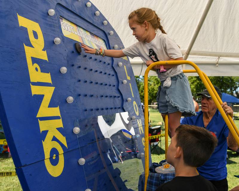 Layla K., 6, of St. Charles plays Plinko while her brother Gavin, 9, watches, during Cortland Summerfest held at Cortland Community Park on Saturday, Aug. 10, 2024.