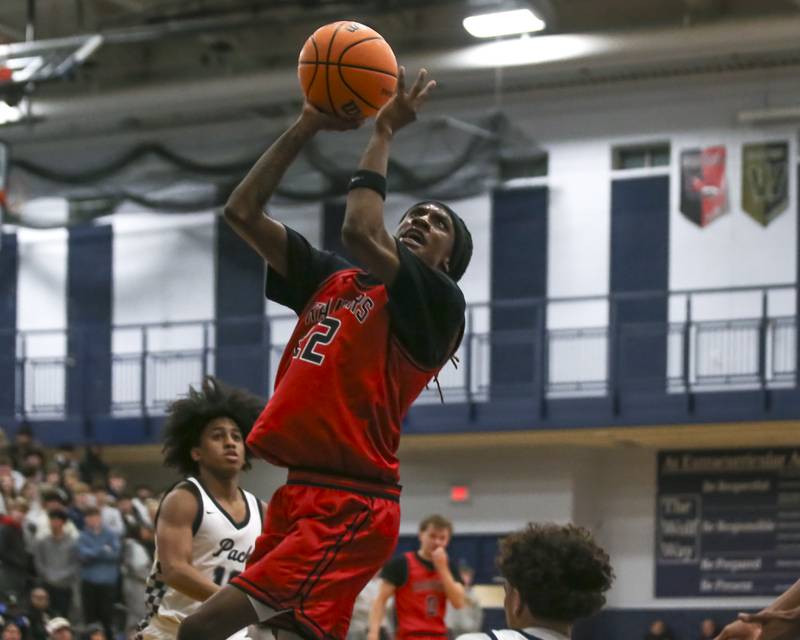 Bolingbrook's Jeremy McCullum (22) goes up over Oswego East's Juan Zavala (21) during their basketball game between Bolingbrook at Oswego East Friday, Jan 30, 2026 in Oswego.