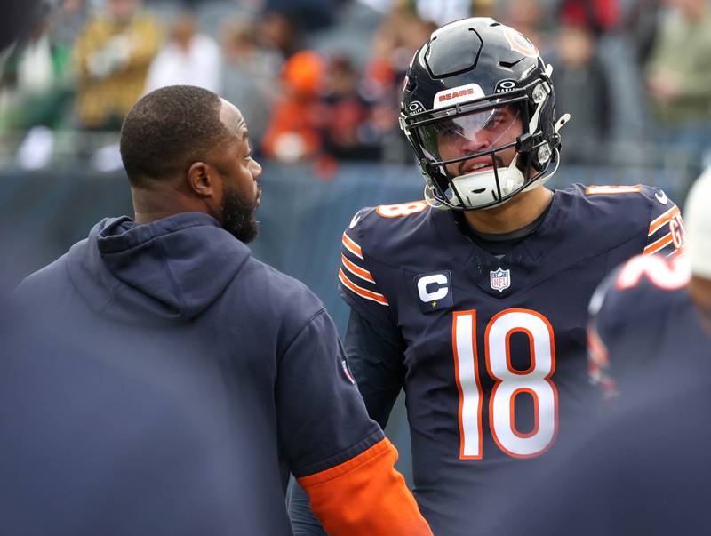 New Chicago Bears offensive coordinator Thomas Brown talks to quarterback Caleb Williams before the they play the Packers Sunday, Nov. 17, 2024, at Soldier Field in Chicago.