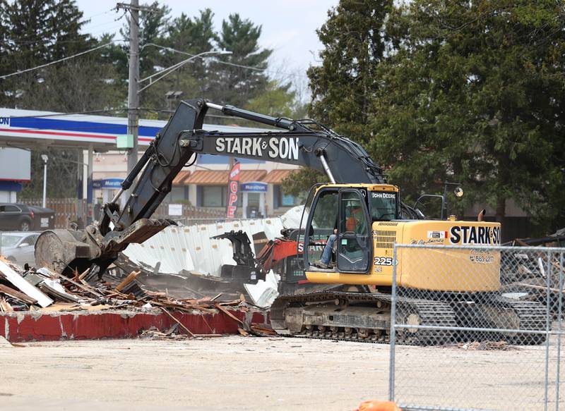 An excavator from Stark & Son clears debris Monday, April 28, 2025, after the former Illini Tire Co. building on the northeast corner West Lincoln Highway and Annie Glidden Road was torn down.