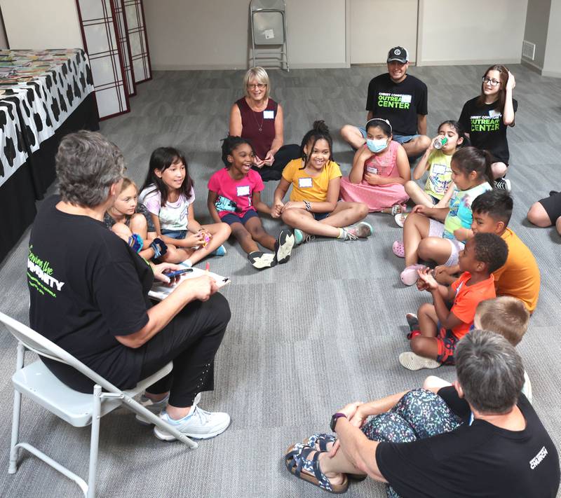 A volunteer from Christ Community Church talks to participants Monday, July 11, 2022, about the activities planned for them this week  during a session of Summer Reading Vacation put on by Neighbors' House in DeKalb in conjunction with the DeKalb County Farm Bureau. Christ Community Church is hosting the camp this week in their outreach center on North 6th Street in DeKalb.