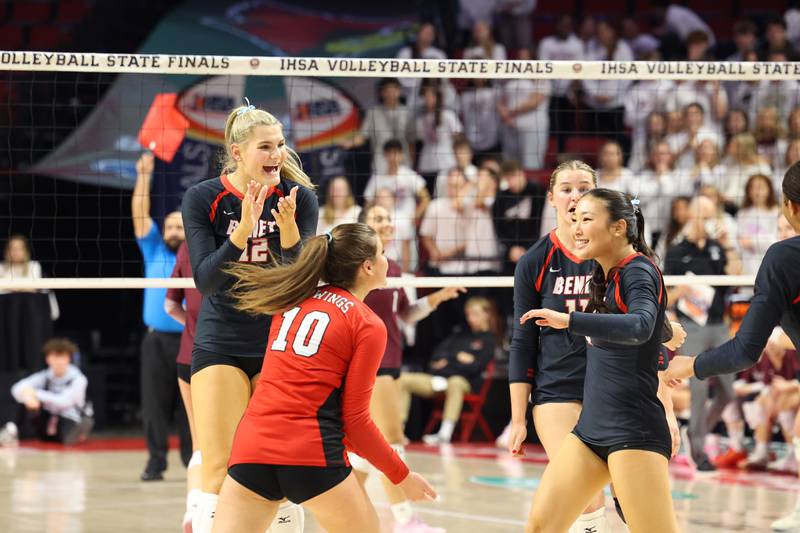 Benet Academy's Lynney Tarnow, left, and Claire Weathers (10) celebrate a point by Abby Lee, right, during Benet Academy's victory in two sets, 25-23, 25-16, over Lockport in the IHSA Class 4A State semifinals on Friday, Nov. 14, 2025.