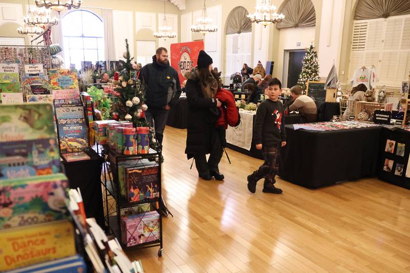 A family bosses the tables at the North Pole Christmas Market inside the Renaissance Center at the Joliet Light Up the Lights Holiday Festival on Friday, Nov. 29, 2024.