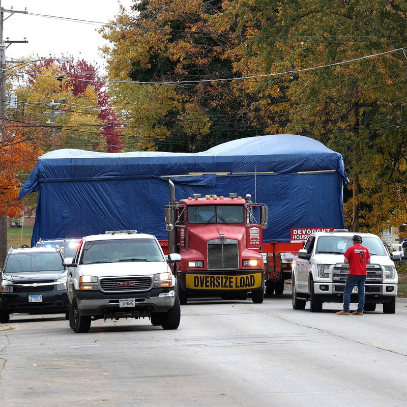 A house has to make a brief stop so a car can be moved out of the way Tuesday, Oct. 22, 2024, as it makes its way down Pleasant Street in DeKalb. The home was moved from the DeKalb County History Center property in Sycamore to its new location on Pleasant Street by Devooght House Movers and Habitat For Humanity for Heaven Allen and her son who will be living in the home when it is completed.