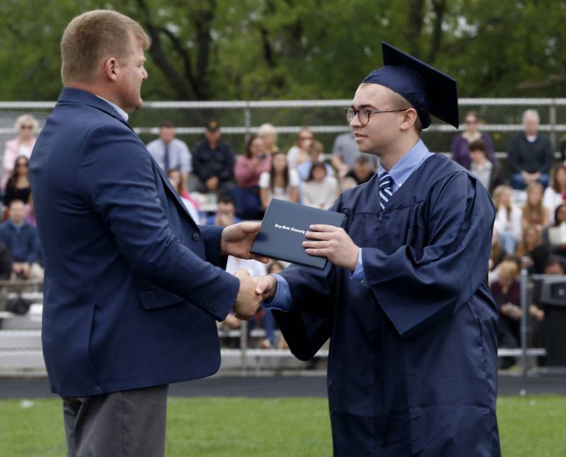 Cameron Adams receives his deploma from Districty 155 school board member, Ron Ludwig, during the graduation ceremony for the class of 2023 at Cary-Grove High School in Cary.