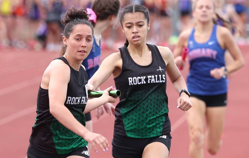 Rock Falls’ Brenna Burlack hands the baton off to Carli Kobbeman during the 4x800 relay Wednesday, May 8, 2024, during the girls track Class 2A sectional at Rochelle High School.