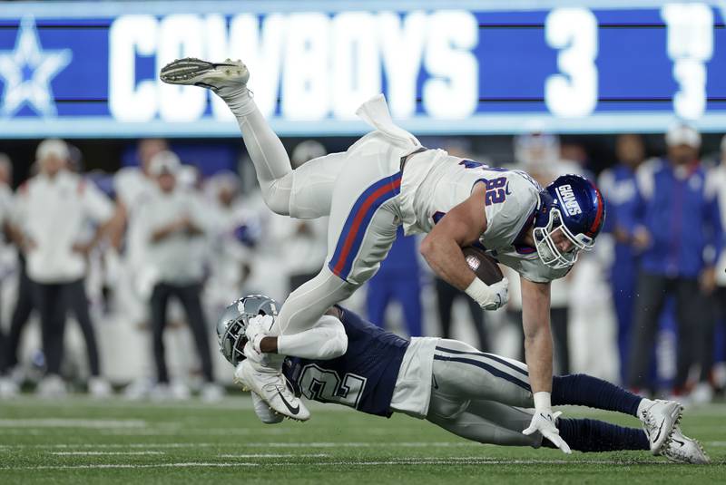 New York Giants tight end Daniel Bellinger (82) is tackled by Dallas Cowboys cornerback Jourdan Lewis (2) during the second quarter of an NFL football game, Monday, Sept. 26, 2022, in East Rutherford, N.J. (AP Photo/Adam Hunger)