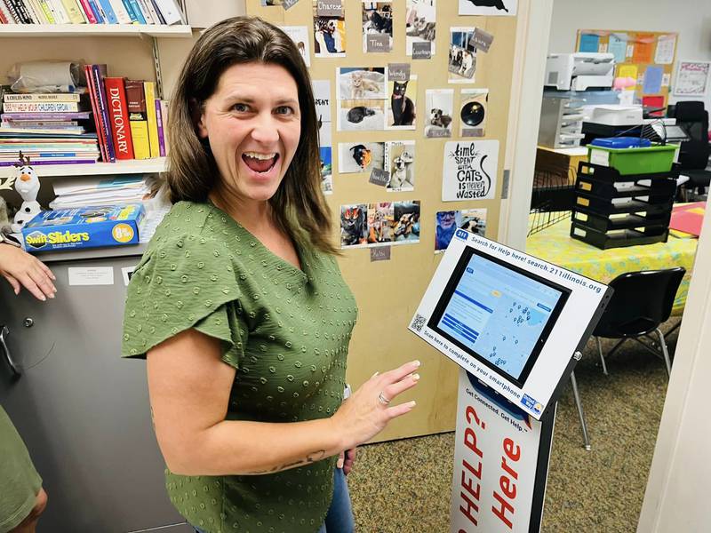 Shannon Alama, of the Children's Learning Center, poses with a new self-help kiosk, meant to provide referrals in real time to community members in need of social services.