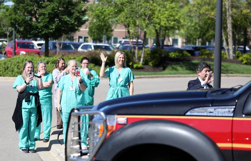 Staff members wave as a Honorarium Brigade travels past Northwestern Medicine Delnor Hospital in Geneva as part of Nurses Week on Wednesday, May 8, 2024.