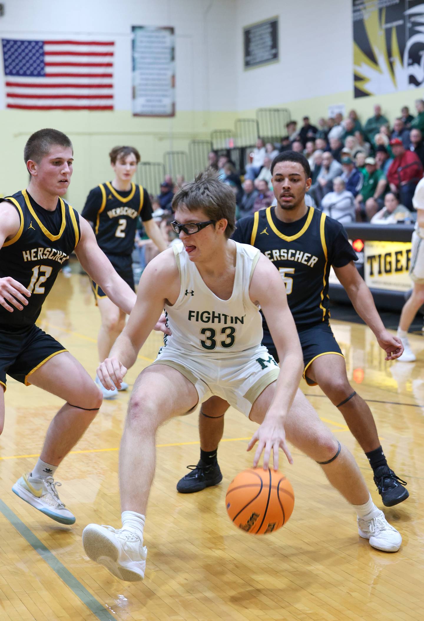 Bishop McNamara's Callaghan O'Connor drives to the lane against Herscher's Gavin Hull, left, during Bishop McNamara's 71-42 victory in the IHSA Class 2A Herscher Regional semifinal on Wednesday, Feb. 25, 2026.