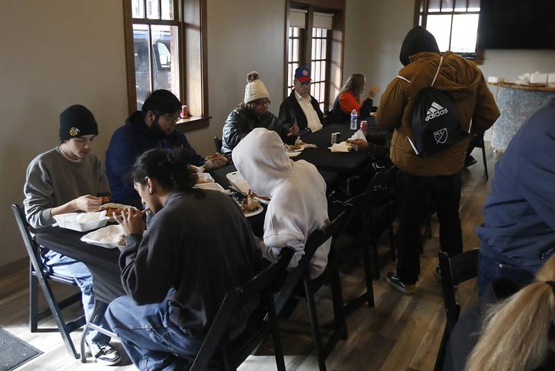 People enjoy a a meal during a free pre-Thanksgiving luncheon on Wednesday, Nov. 22, 2023, at the Woodstock train depot. This is the second year the meal that was provided through efforts of Warp Corps, MBI Cares, Isabel’s Family Restaurant, and Napoli’s Pizza, all located in Woodstock