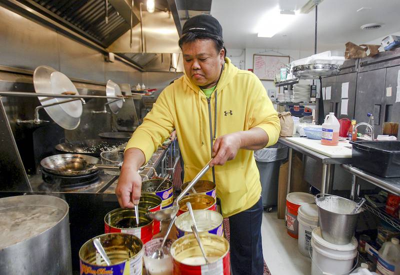 Owner William Gee cooks pork fired rice Wednesday during the lunch hour rush at New China Restaurant in Fox River Grove. The restaurant reopened in September with help from donations from the community.