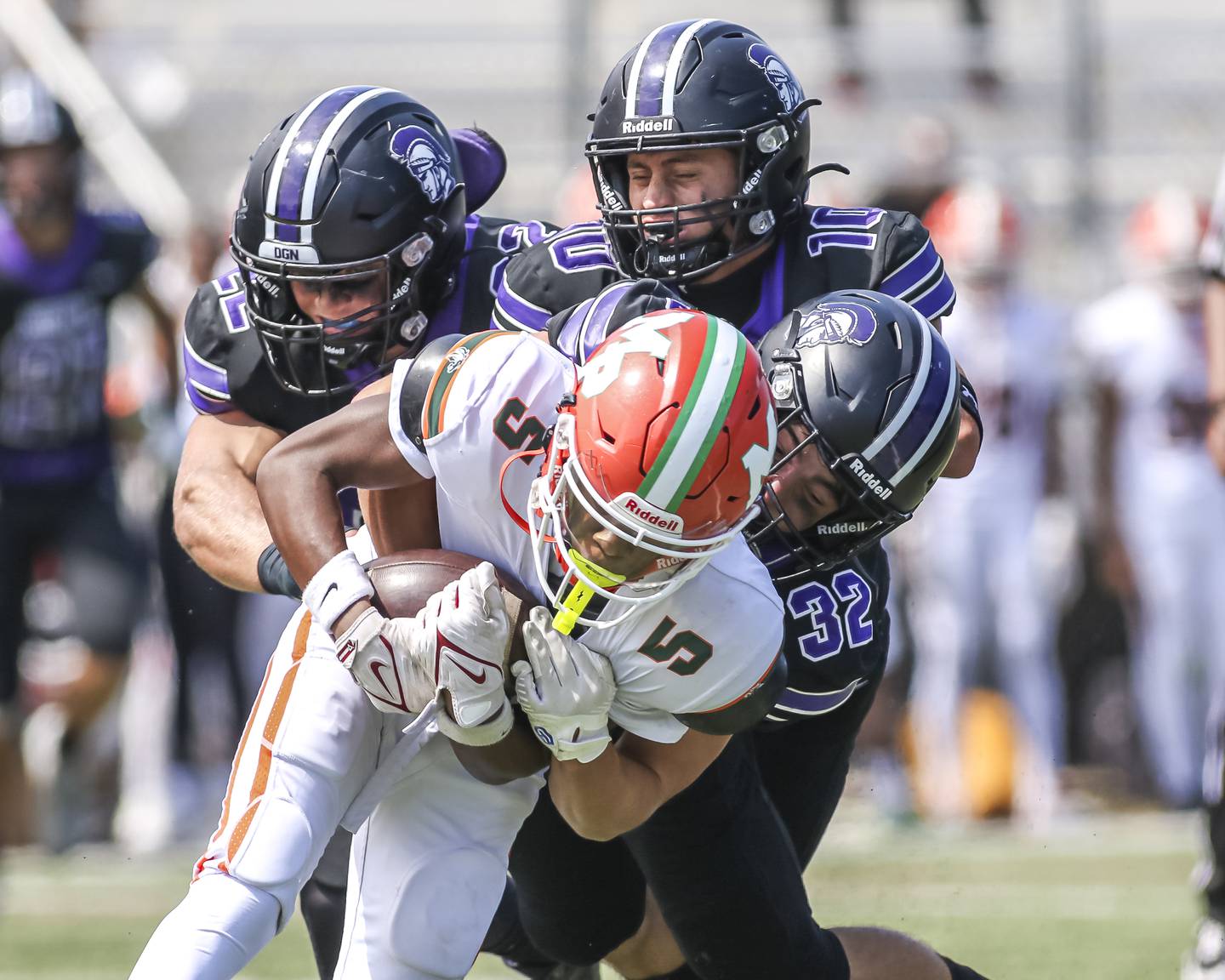 Downers Grove North's Joe Lasota (22), Oliver Thulin (10) and Baker Glomb (32) bring down Morgan Park's Travezz Jones (5) during football game between Downers Grove North at Morgan Park Saturday, Aug 30, 2025 in Chicago.
