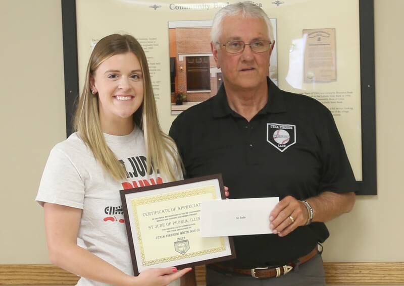 Madison Shaffer receives a donation from Utica Fireside White Sox Club member Randy Tuftie during the 14th annual Utica Fireside White Sox Club donation presentation on Tuesday, Aug. 15, 2023 at the Utica Township Community Building. Shaffer is a 24 year survivor of St. Jude.