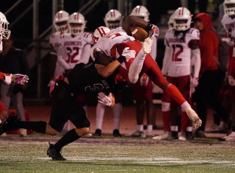 Downers Grove North's Jameson Ordway (3) upends Kenwood's Ethan Middleton (5) after the catch during a class 7A playoff football game at Downers Grove North on Friday, Oct. 27, 2023.