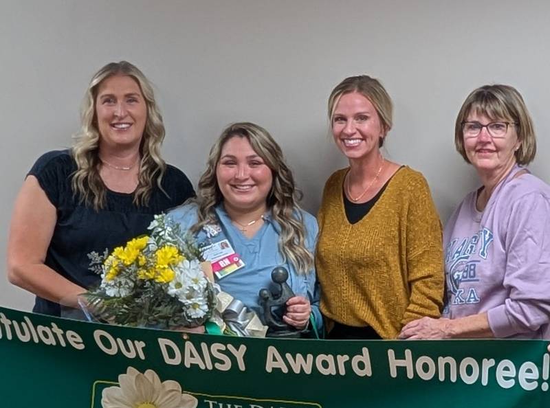 OSF HealthCare Saint Katharine Medical Center third quarter DAISY award winner Kaitlynn Pfeiffer, RN, (second from right) stands with the survivor and her family. Pfeiffer helped the woman who was medical distressed at a youth baseball game.