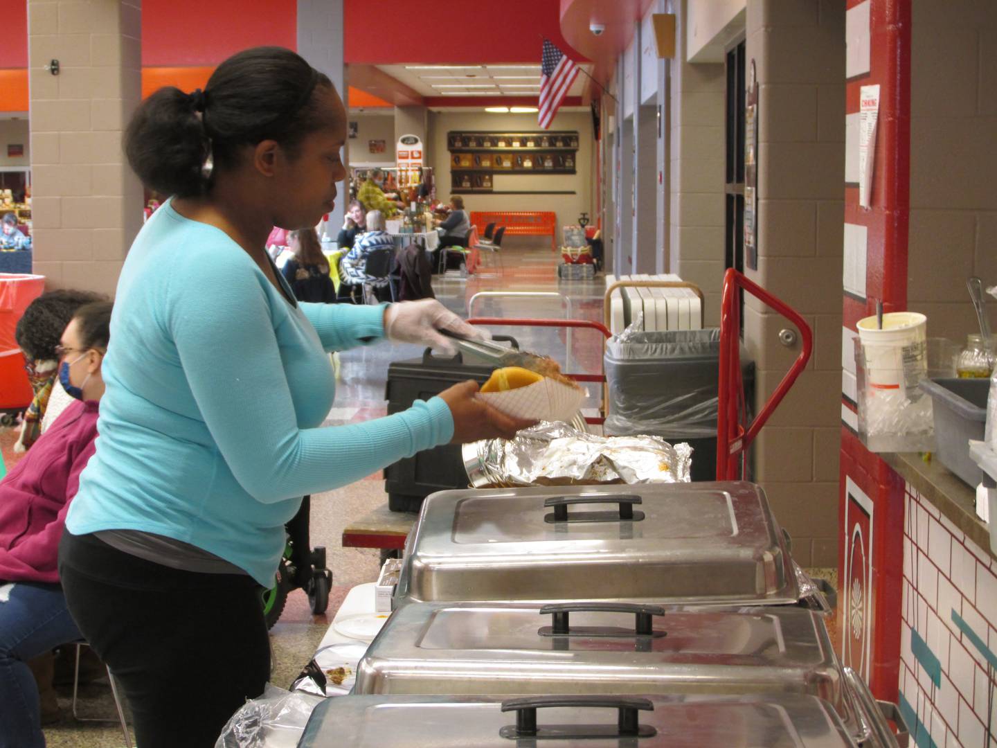 Joi Ruffin, of Dig Doug's barbecue, serves a prepared a sandwich Sunday, Nov. 13, 2022, during Streator Unlimited's Food for Thought fundraiser at Streator High School.