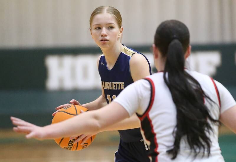 Marquette's Chloe Larson looks to pass the ball off as Amboy/Ohio's Kenley Wilson defends during the Class 1A Regional championship on Thursday, Feb. 20, 2025 at St. Bede Academy.